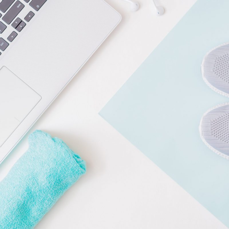 Home online workout concept. Flat lay sport shoes, new sneakers, laptop on a light background